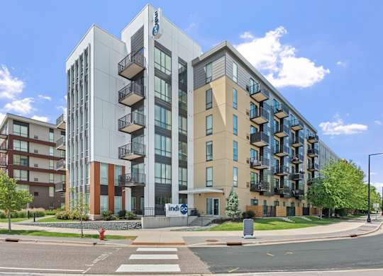 A modern apartment building with a glass facade and balconies.