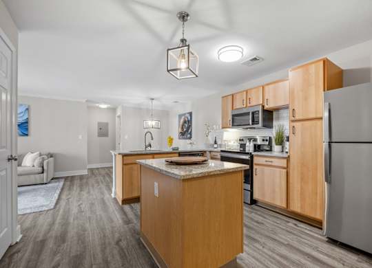 A kitchen with a refrigerator, microwave, and oven.