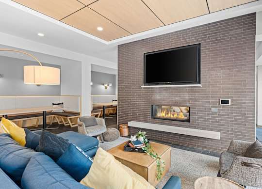 A modern living room with a fireplace and a flat screen TV mounted on the wall.