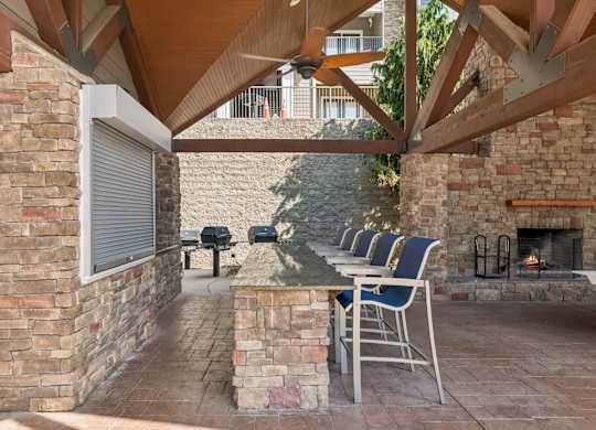 A patio with a fireplace and chairs.