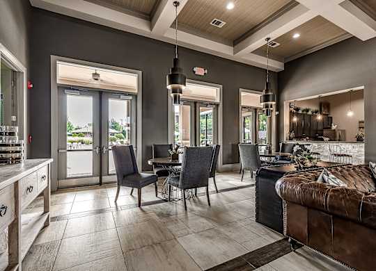 A modern living room with a brown couch and a dining table with chairs.