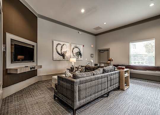 A living room with a grey couch and a fireplace.