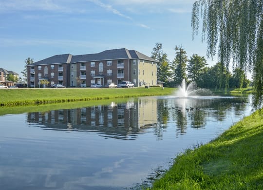 Lush Green Grass Surrounding the Large Pond with Fountain