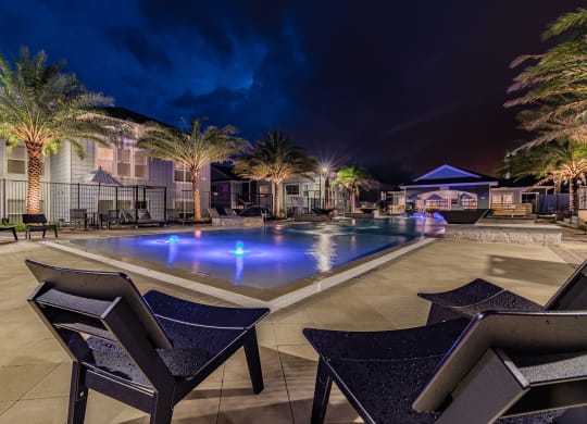 Expansive Outdoor Pool Sundeck Lit Up At Night