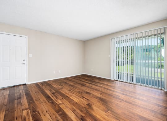 Living Room Area With Wood-Style Flooring & Glass Sliding Patio Door With Built-In Blinds