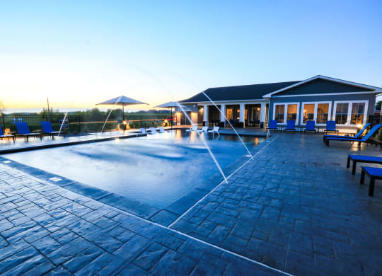 Resort-Style Pool With Fountains At Dusk