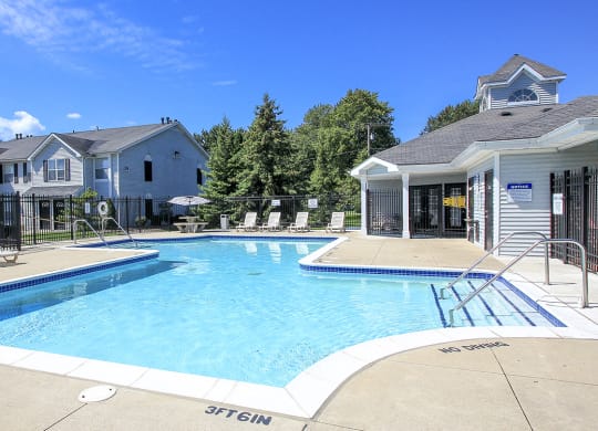Fenced-In Outdoor Pool with Lounge Furniture