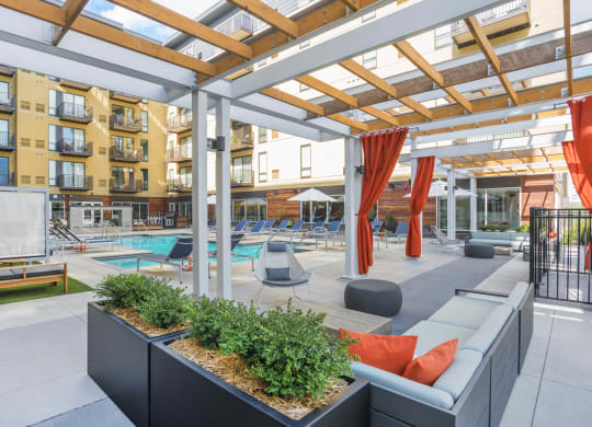 a communal area with couches and plants in front of an apartment building