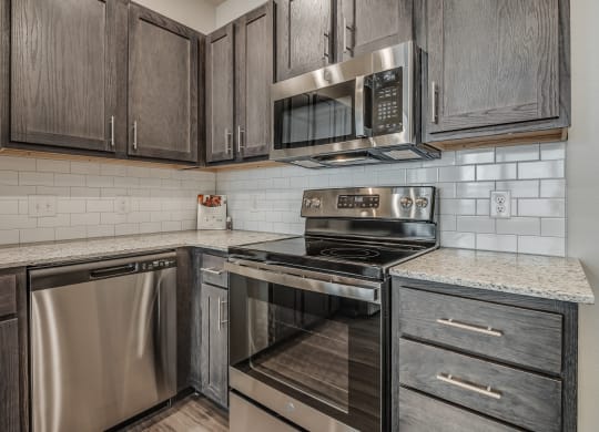 Kitchen with Dark Brown Cabinetry and Stainless Steel Appliances
