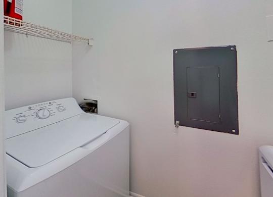 A white washing machine sits in a laundry room.