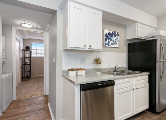 Renovated Kitchen with White Tile Backsplash and Stainless Steel Dishwasher and Fridge