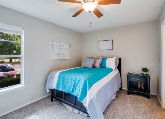 Bedroom with Large Window and Ceiling Fan with Light