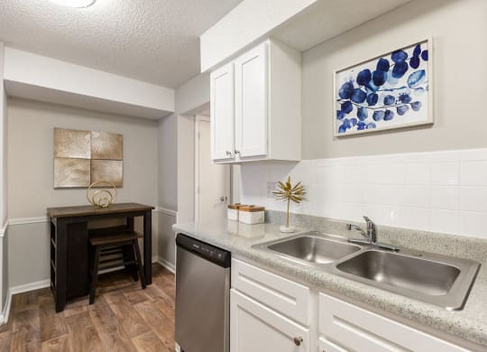 Renovated Kitchen with White Cabinets and Light Grey Countertops with High Top Table in the Dining Room