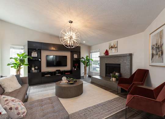A community room with a fireplace, couches, and a television.