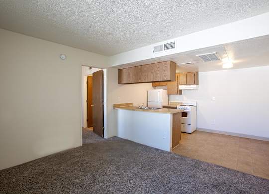 A kitchen area with a white counter and a white refrigerator.
