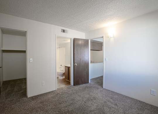 A room with a carpeted floor and a white door.