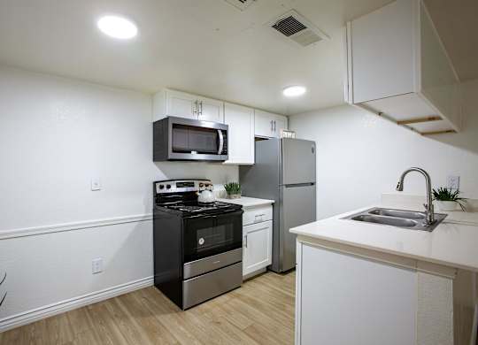 A kitchen with white cabinets and a black stove top oven.