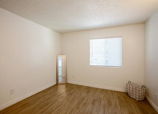 A room with a door and a window with blinds.