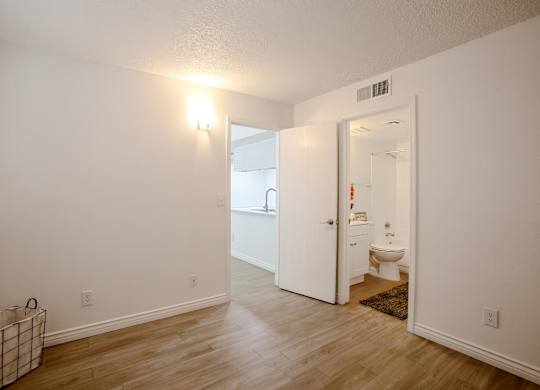 A room with a white door leading to a bathroom.