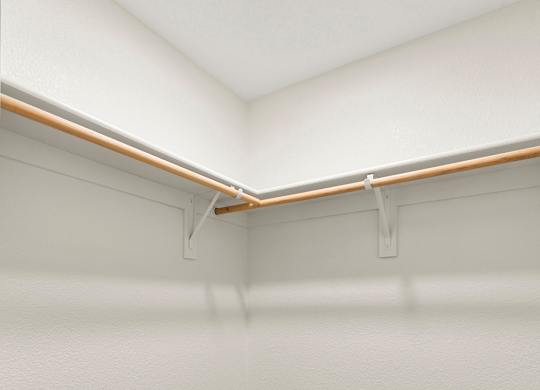 A white wall with a grey carpet and a white ceiling with a light on.