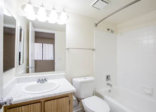 A white bathroom with a sink, toilet, and bathtub.