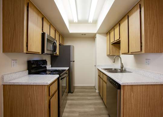 A kitchen with wooden cabinets and a black stove top oven.