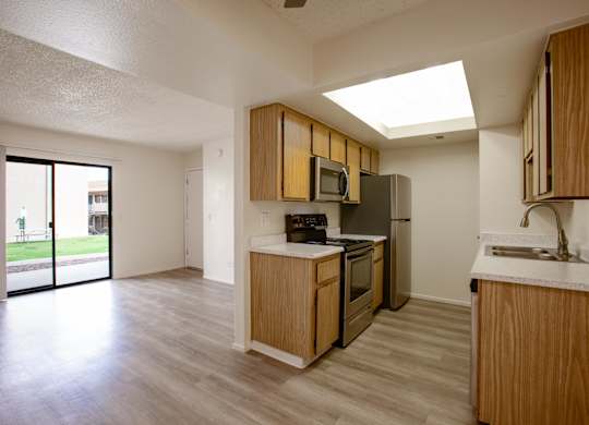 A kitchen with wooden cabinets and a skylight.