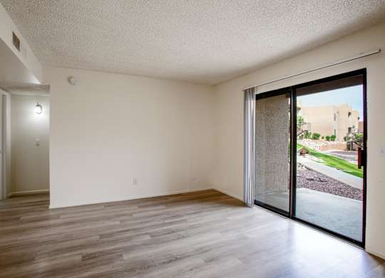 A room with a sliding glass door leading to a backyard.
