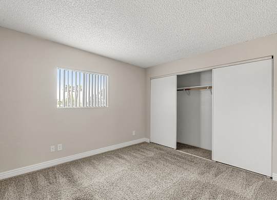 A room with a carpeted floor and a sliding door.