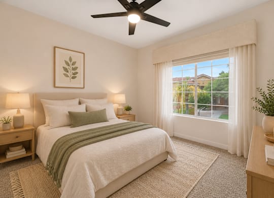 A bedroom with a large bed, a ceiling fan, and a window with curtains.