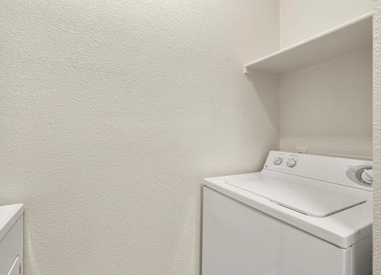 A white washing machine in a small laundry room.