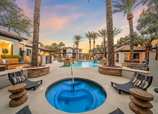 a swimming pool with a fountain at a resort with palm trees