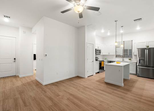 A kitchen with a white fridge and wooden floors.