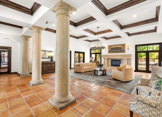 A spacious living room with a fireplace and a large rug.
