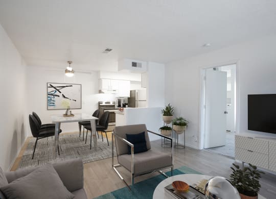 a furnished living room with a dining room table and chairs and a kitchen in the background