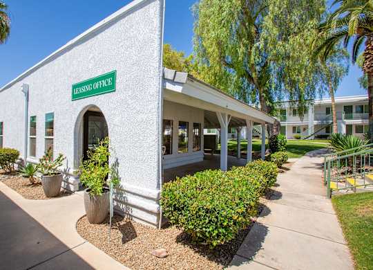 A white building with a green sign that says