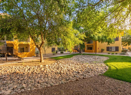 A yellow house with a tree in front of it.