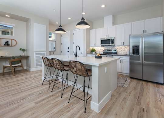 A kitchen with a white island and stainless steel appliances.