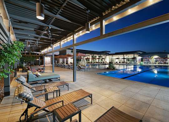 A pool area with a table and chairs.