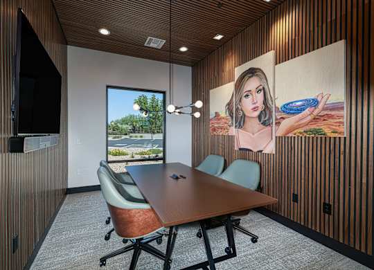 A conference room with a large table and chairs, a television, and a large painting on the wall.