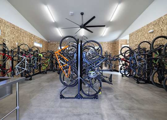 A room full of bicycles with a ceiling fan.
