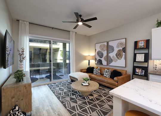 A living room with a couch, a coffee table, and a ceiling fan.