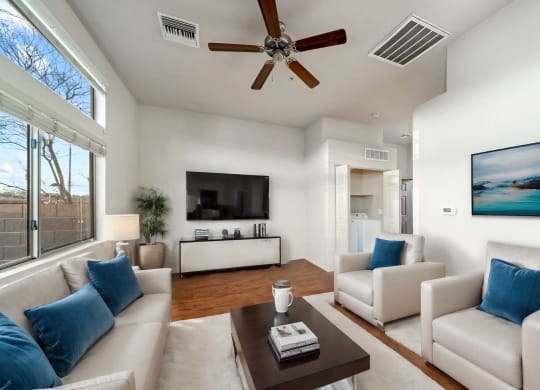 Living Room with Ceiling Fan and Washer and Dryer at Avilla Preserve Apartment Homes in Tucson Arizona