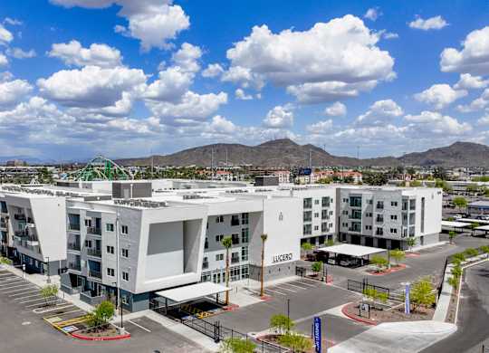 A Lucido apartment complex with a parking lot in front.