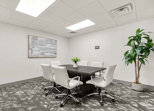 A conference room with a large table and chairs.