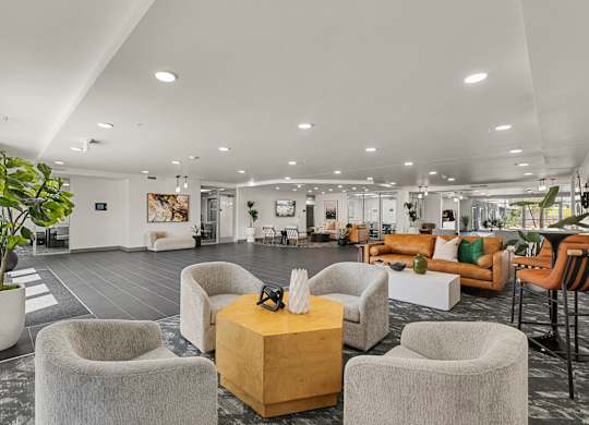A modern living room with grey chairs and a wooden coffee table.