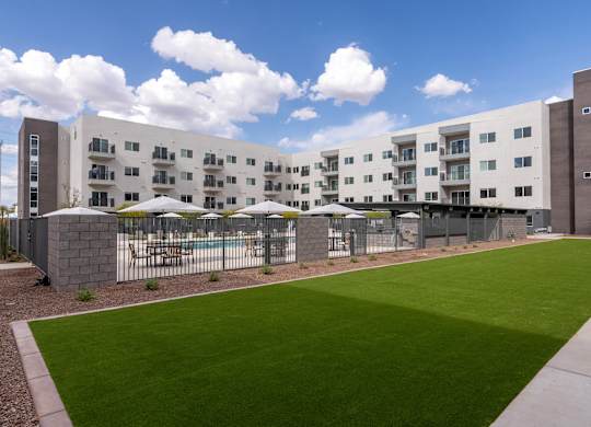 A large white building with a green lawn in front.