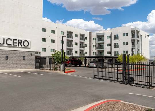 The Lucero building has a black gate and a red brick border.