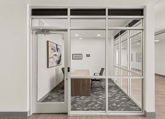 A glass door with a white frame leads to a room with a table and chairs.