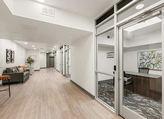 A hallway with a glass door and a plant in the background.